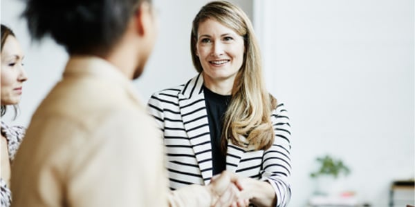 Two people shaking hands during a business meeting.
