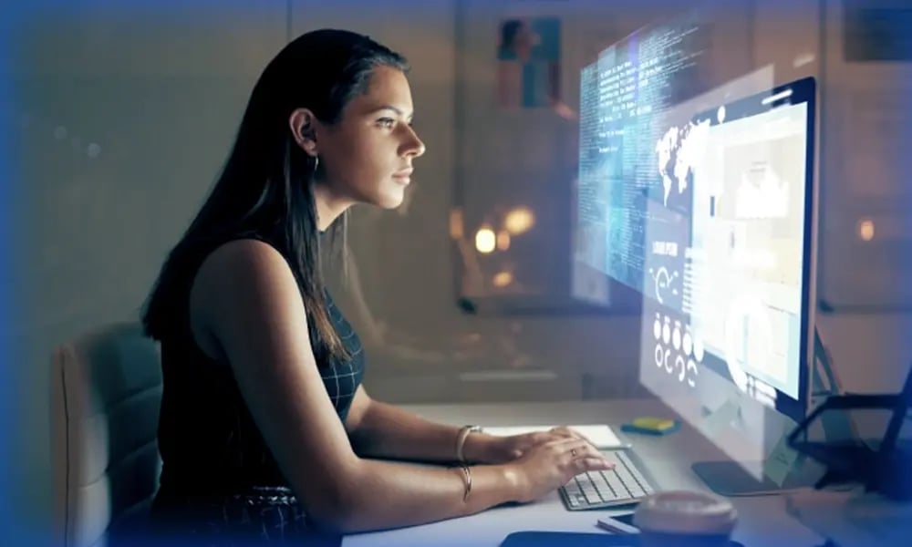 Person working at a computer with data and analytics displayed on the screen.