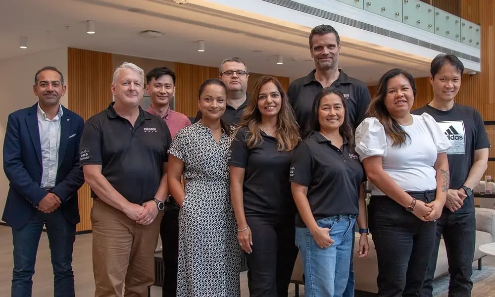 Group standing inside a modern office space for a team photo.