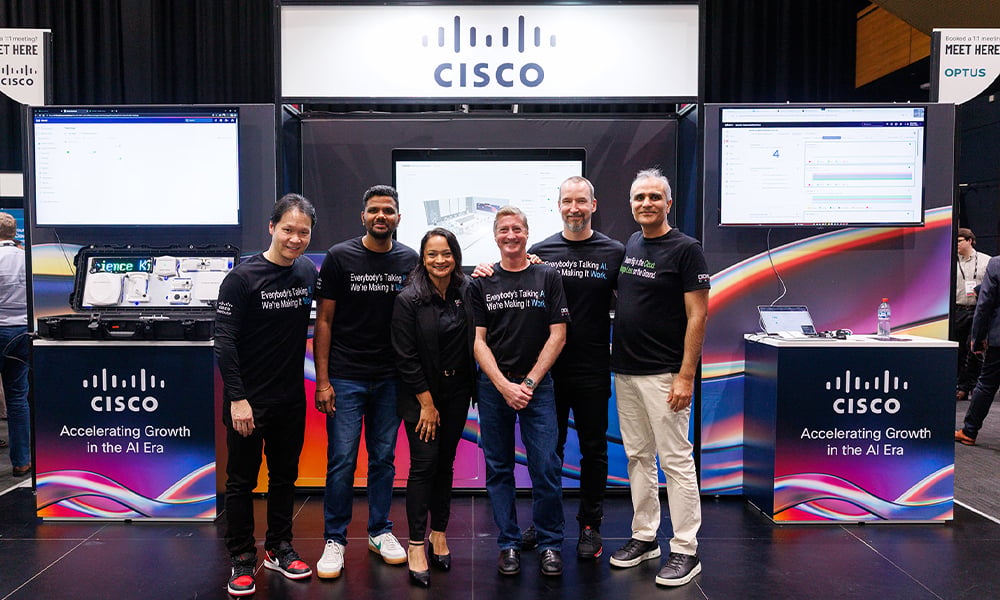 Group of people standing in front of Cisco stand at TechX