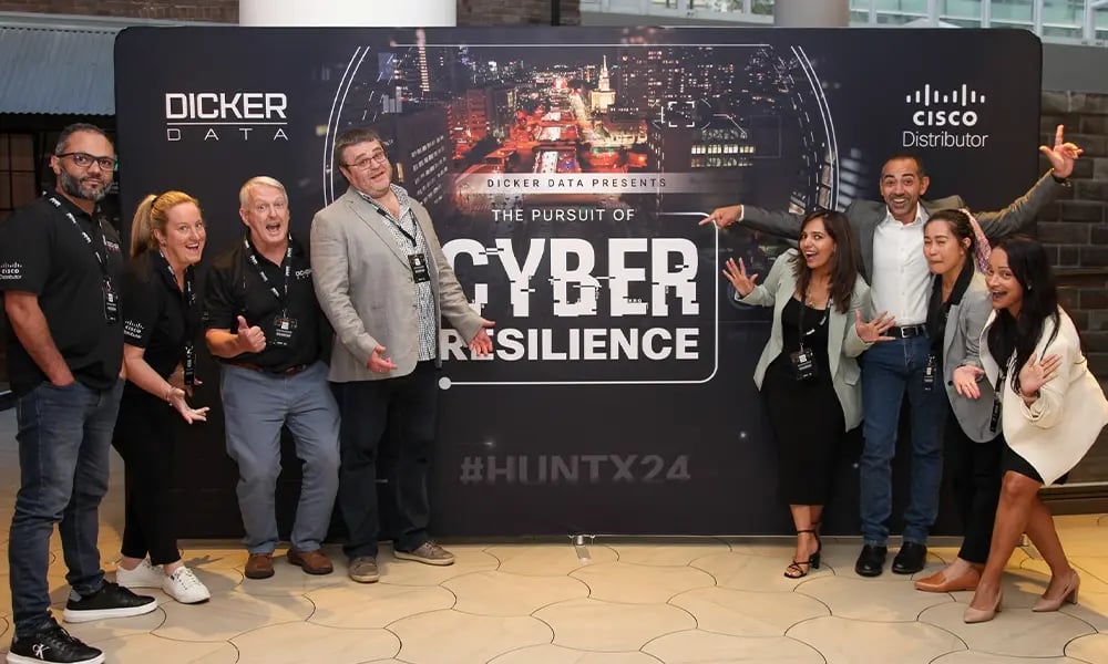 Team posing in front of a branded backdrop for a cyber resilience event.