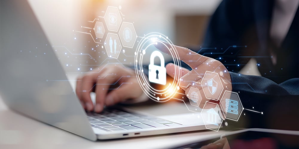 Hands typing on a laptop with a digital padlock and cybersecurity icons overlaid.