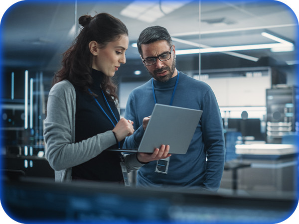 Two colleagues reviewing information on a laptop in a modern office.