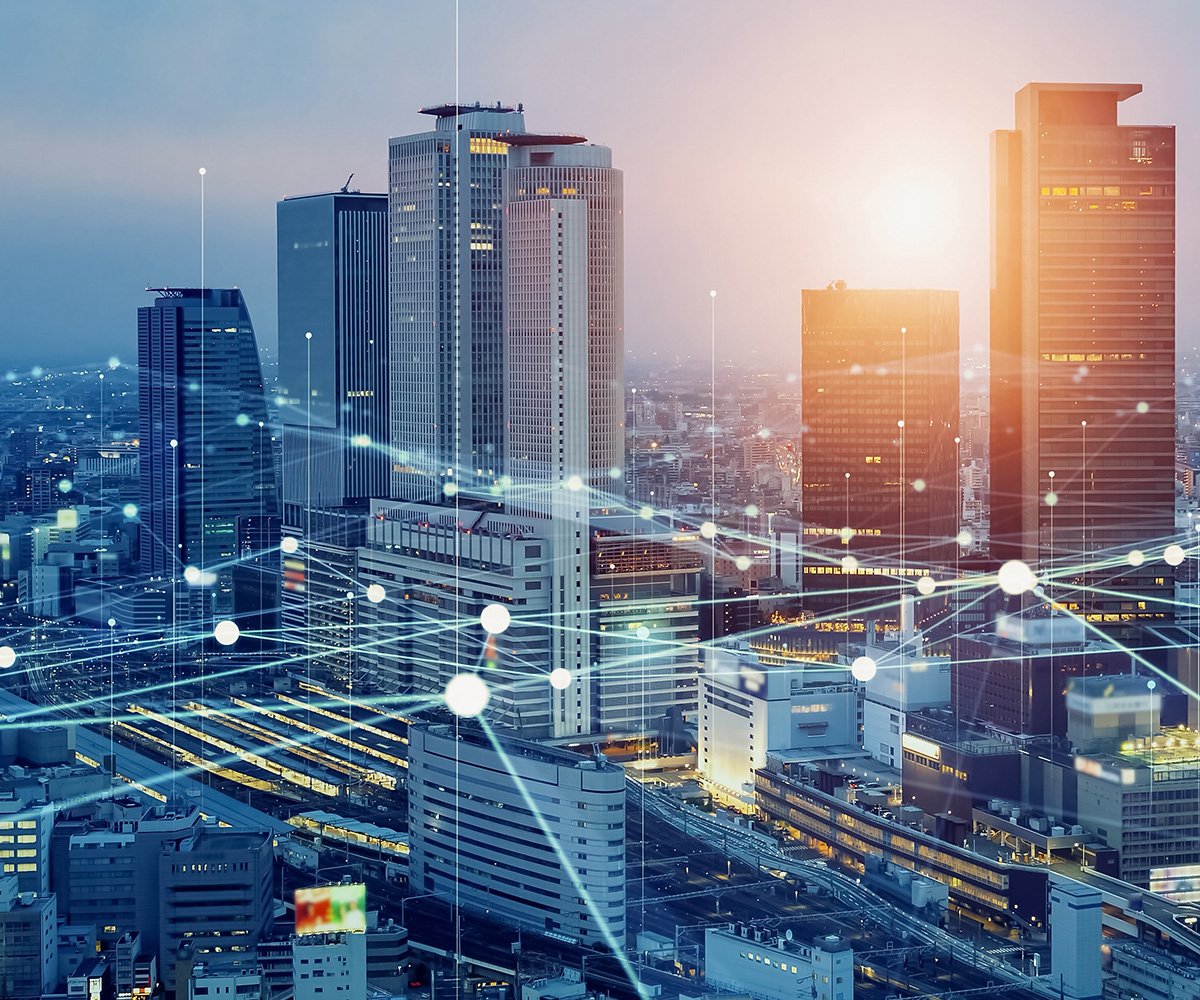 City skyline at sunset with high-rise buildings and digital network lines connecting across the urban landscape