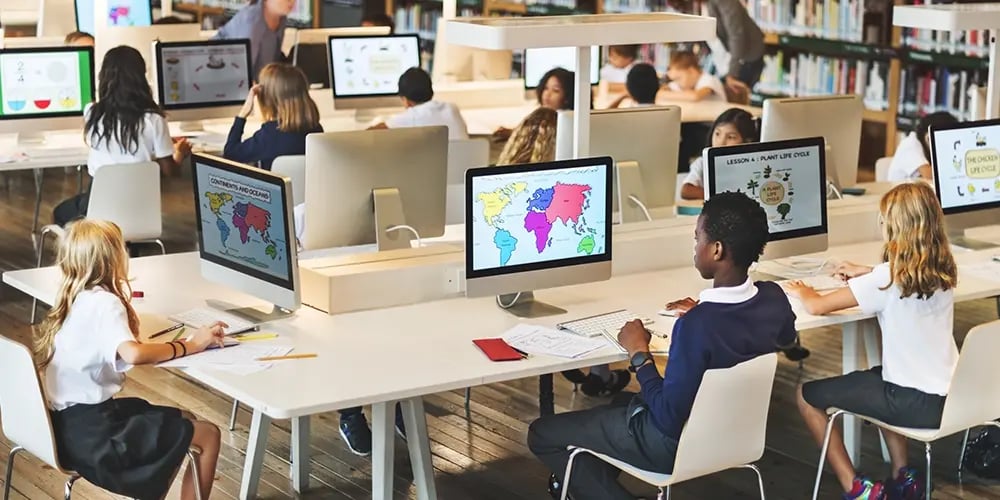 Classroom with students working on desktop computers, illustrating the need for reliable backup power solutions to maintain continuous learning.