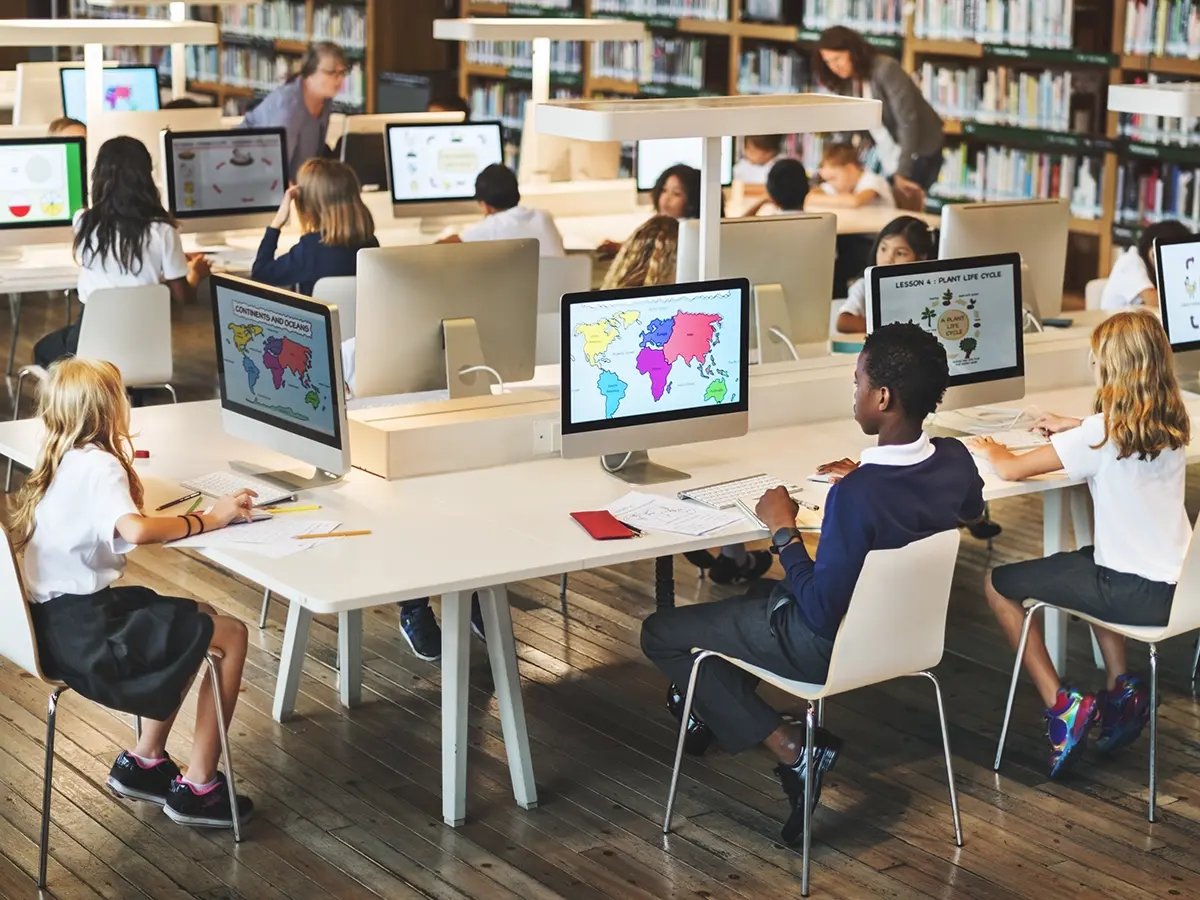 Classroom with students working on desktop computers, illustrating the need for reliable backup power solutions to maintain continuous learning.