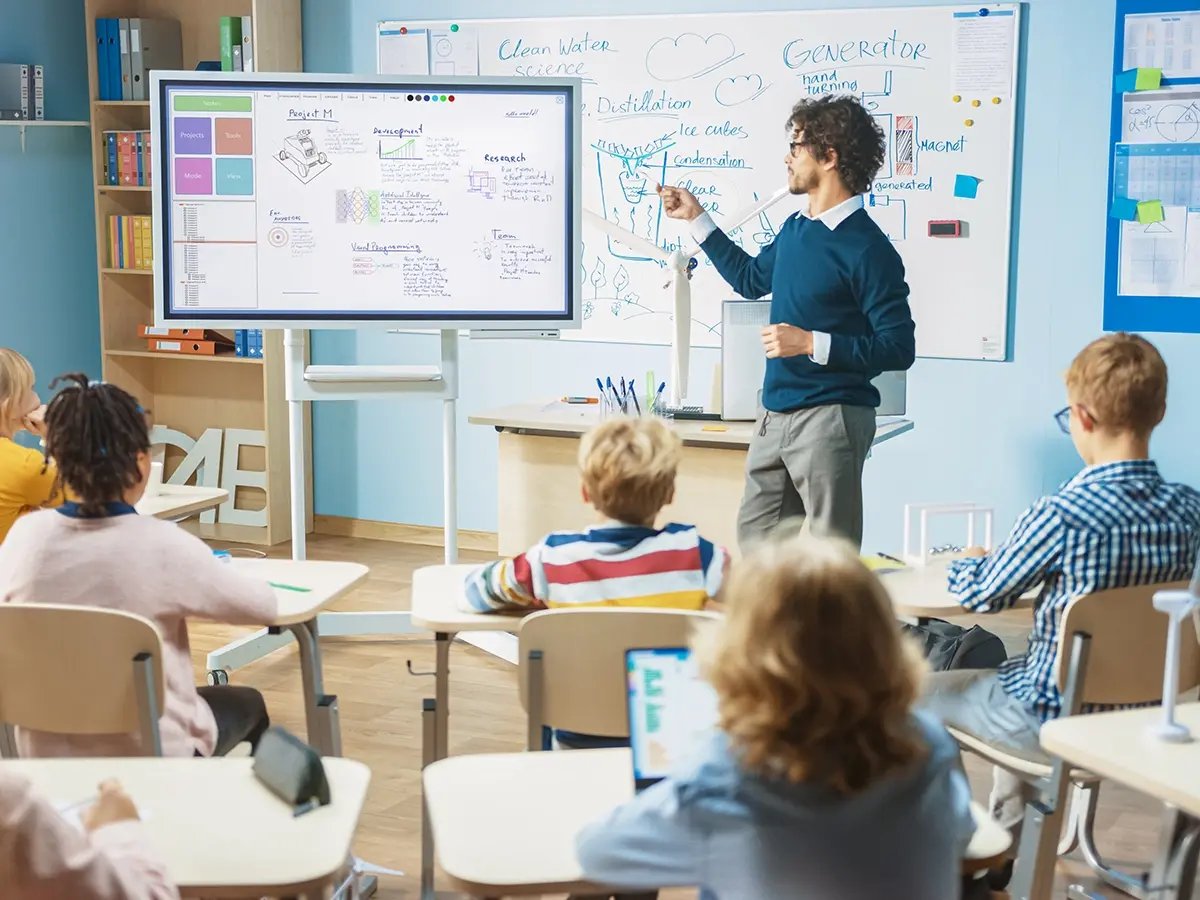 Interactive digital display showing diagrams and notes in a classroom setting, used for teaching alongside a whiteboard.