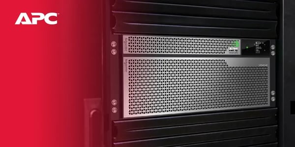 Close-up of an APC server rack with a perforated metal front panel and status indicators.