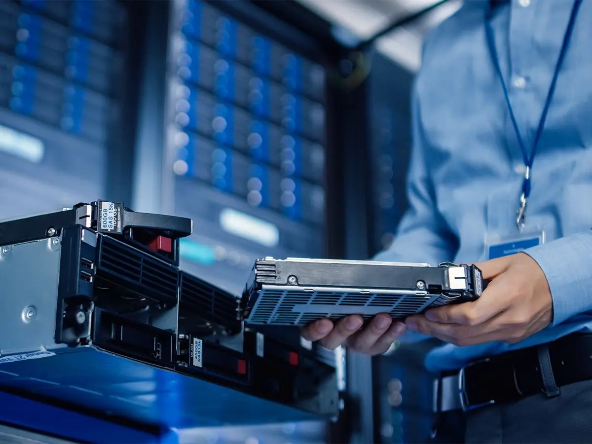 Technician handling server hardware in a data centre.