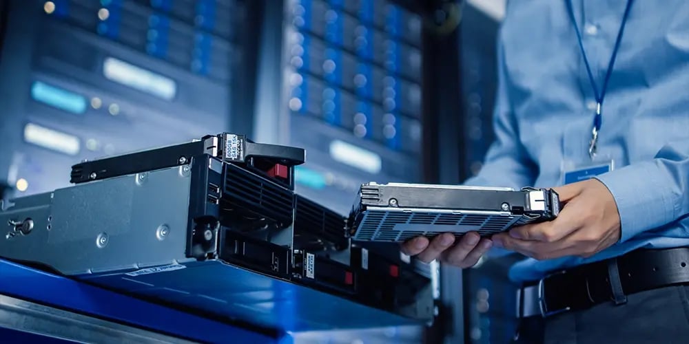 Technician handling server hardware in a data centre.