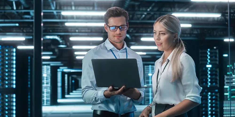 Two professionals reviewing information inside a high-tech facility.