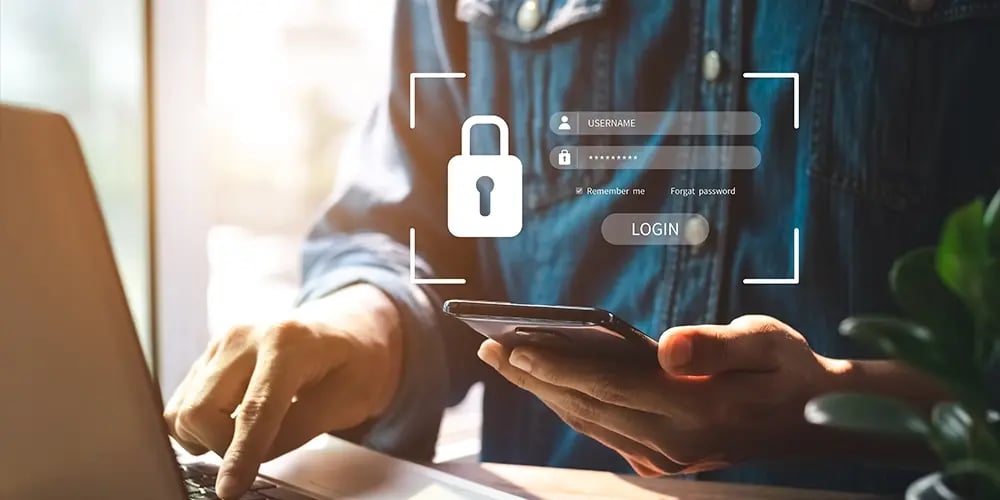 Person using a smartphone and laptop with a secure login interface overlay.