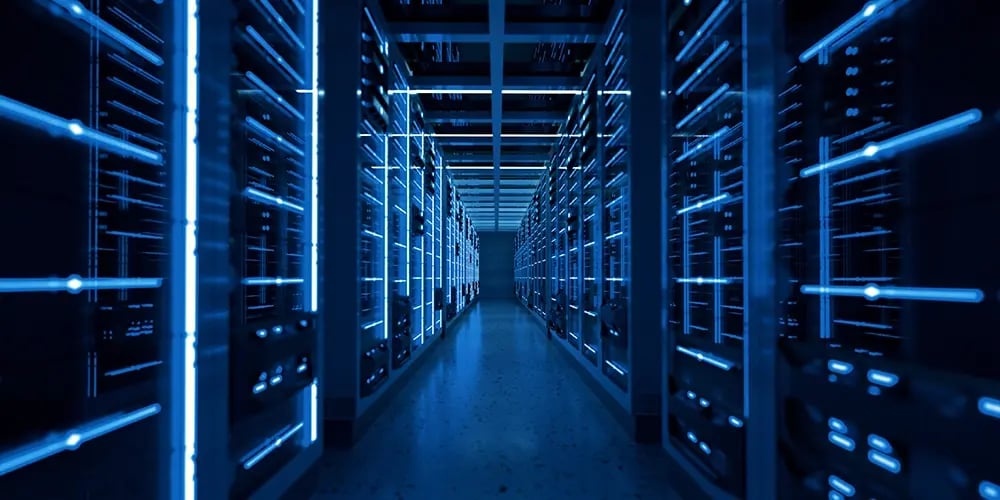 A glowing aisle of blue-lit server racks inside a modern data center.