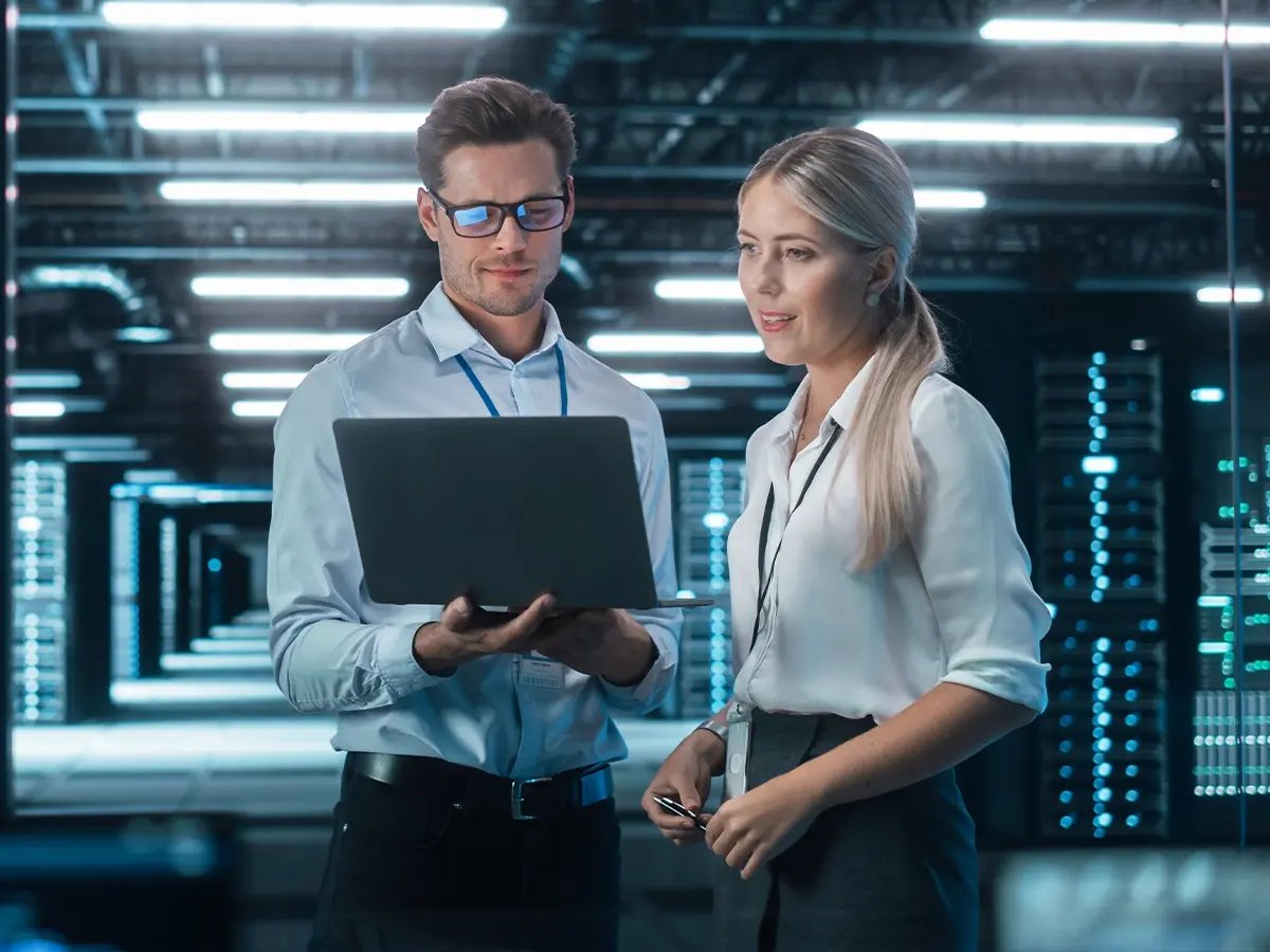 Two professionals reviewing information inside a high-tech facility.