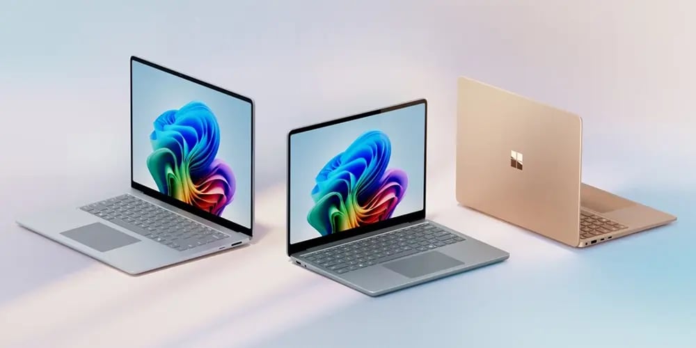 Three Microsoft Copilot+ laptops displayed on a light background, featuring sleek designs and vibrant screens with colorful abstract graphics.