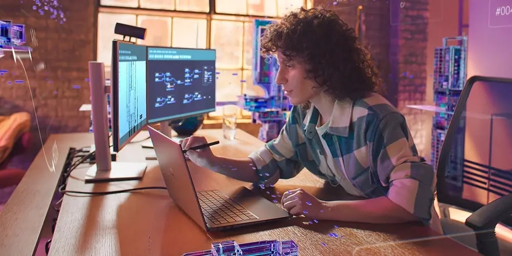 Modern workstation setup with a laptop and dual monitors displaying technical diagrams and code, on a wooden desk in a stylish office.