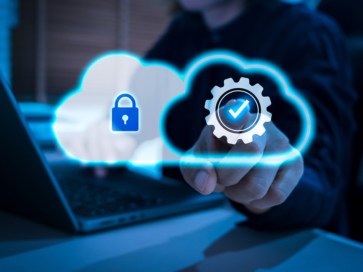 Cloud icons with a lock and check symbol floating above a laptop to represent secure cloud services.