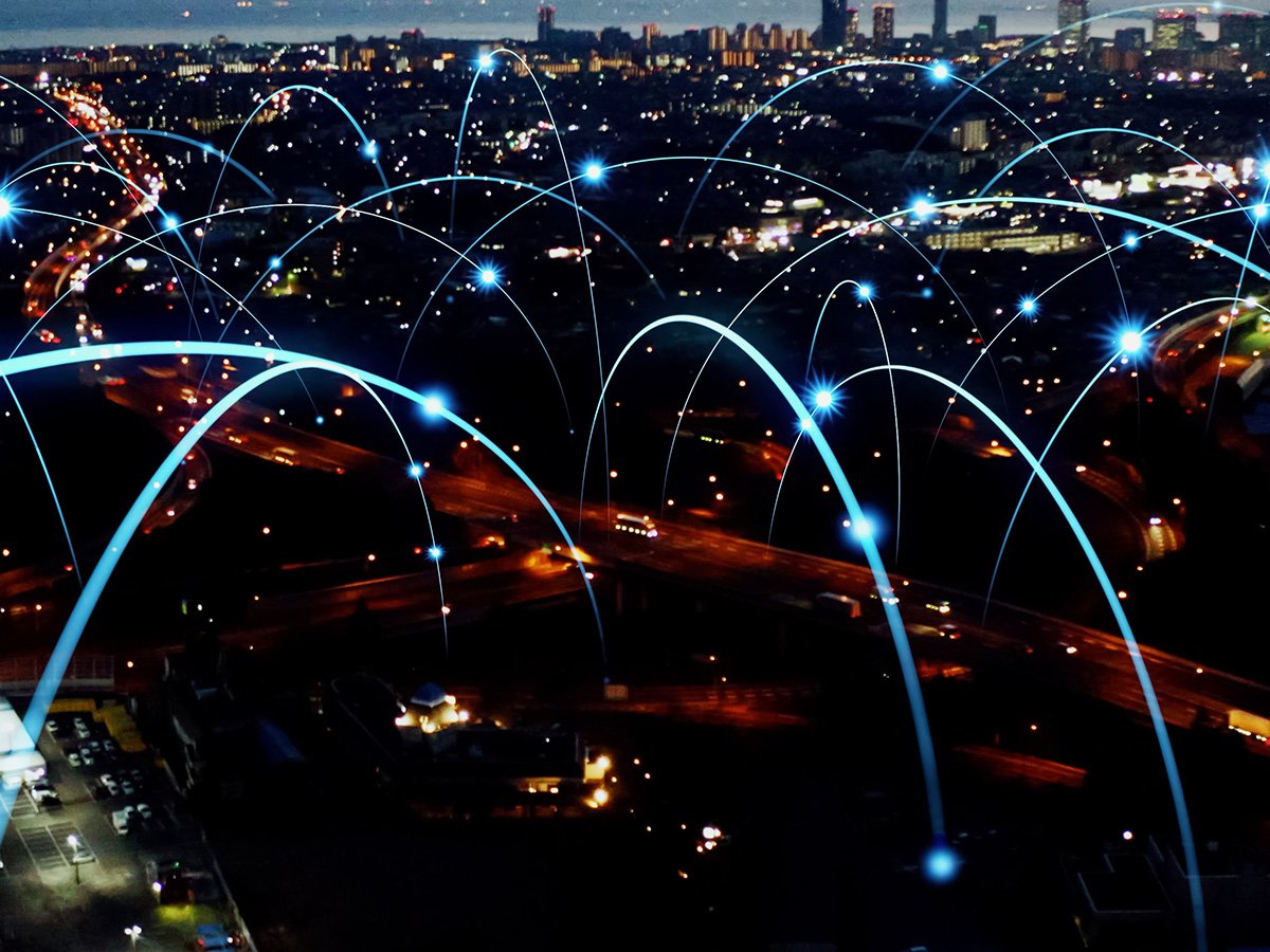 Night cityscape with digital arcs connecting locations, representing wide‑area network connectivity.