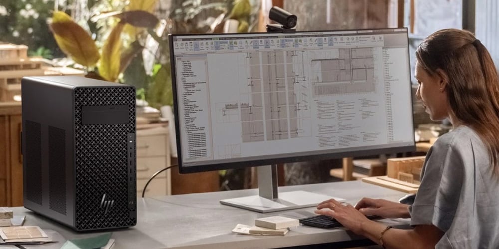 Person working at a large monitor displaying architectural design software.