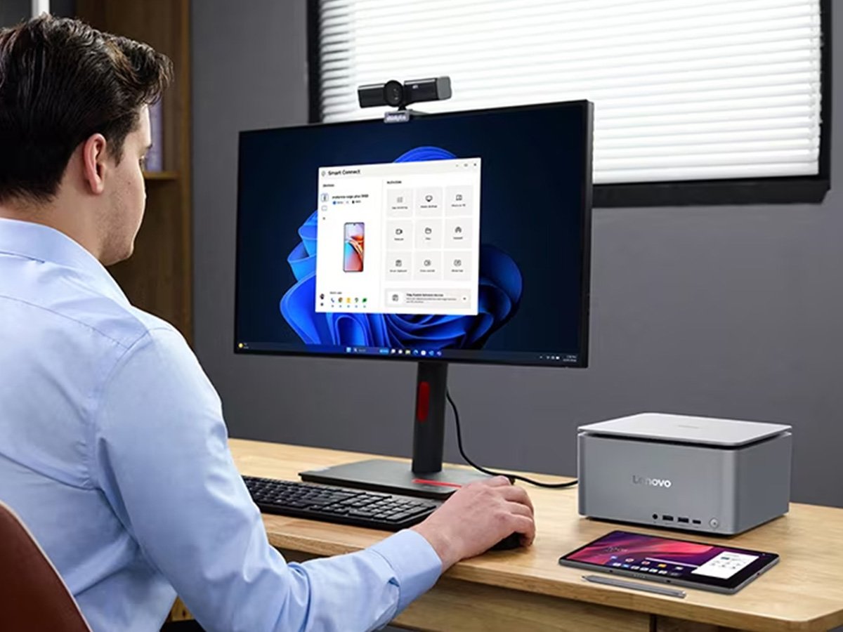 Person using a desktop setup with a monitor showing a device‑connection app.