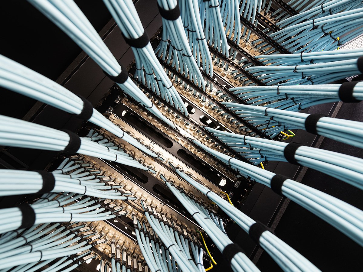 Close‑up of network cables connected to servers inside a data centre rack.