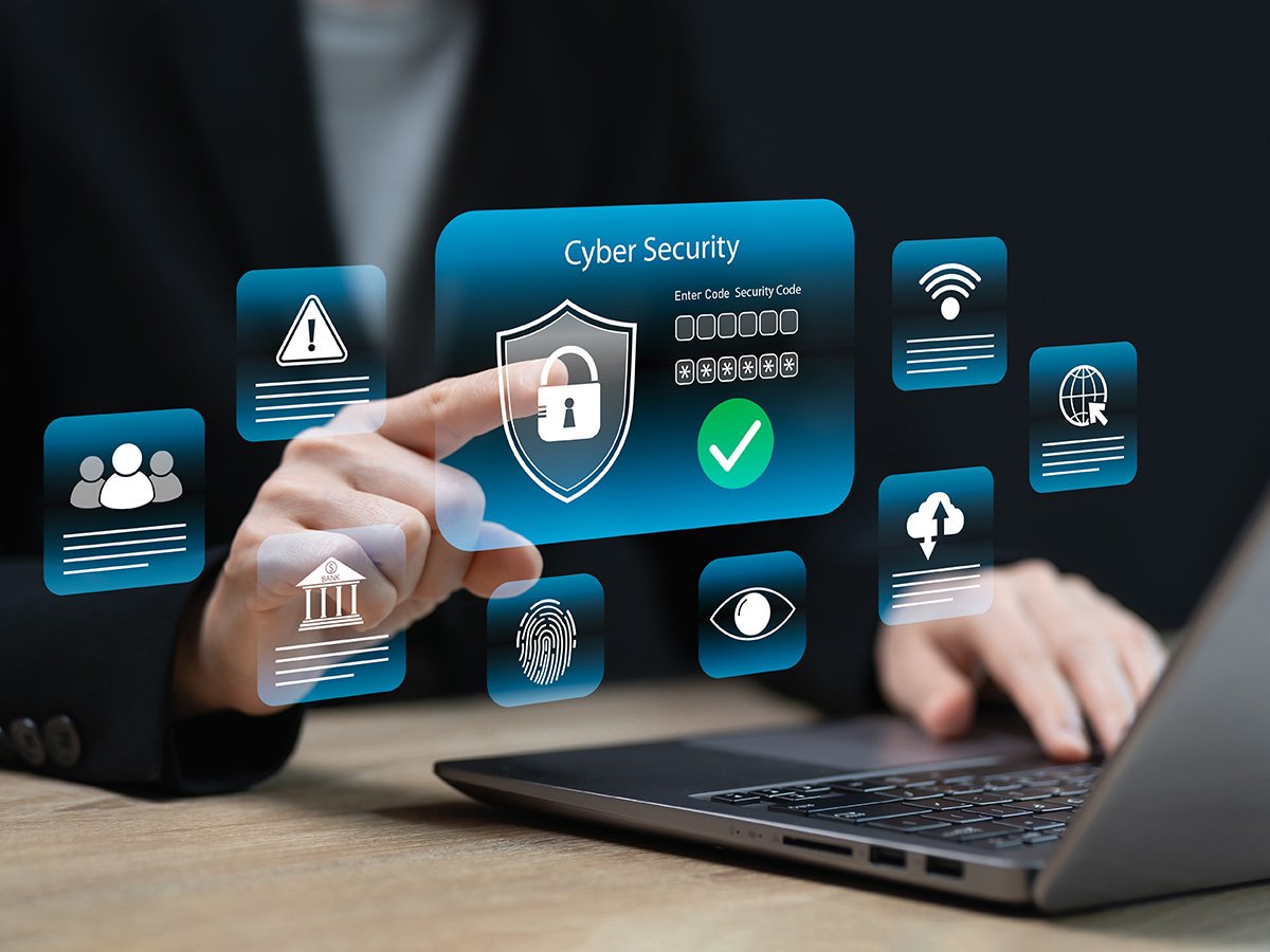 Person interacting with a digital cyber security interface showing a lock, verification icons and data panels.