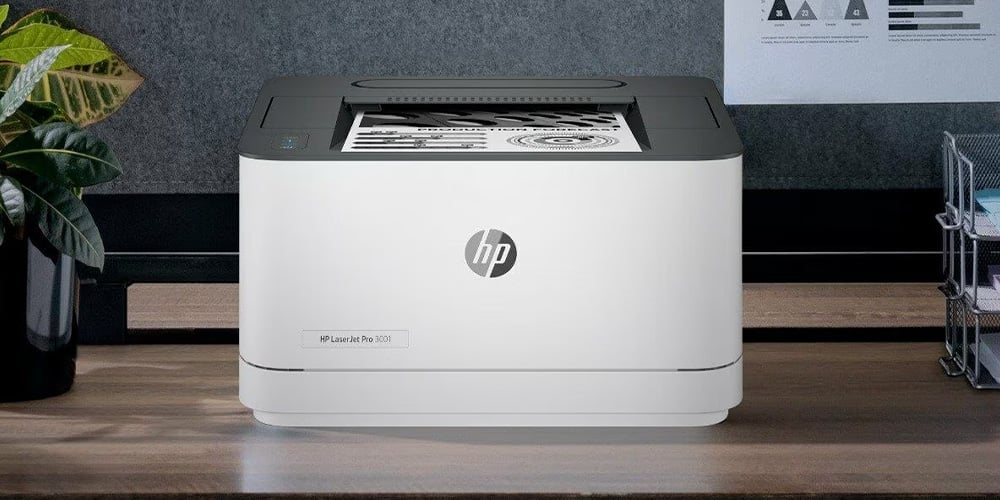 HP LaserJet Pro printer on a wooden desk with printed pages.