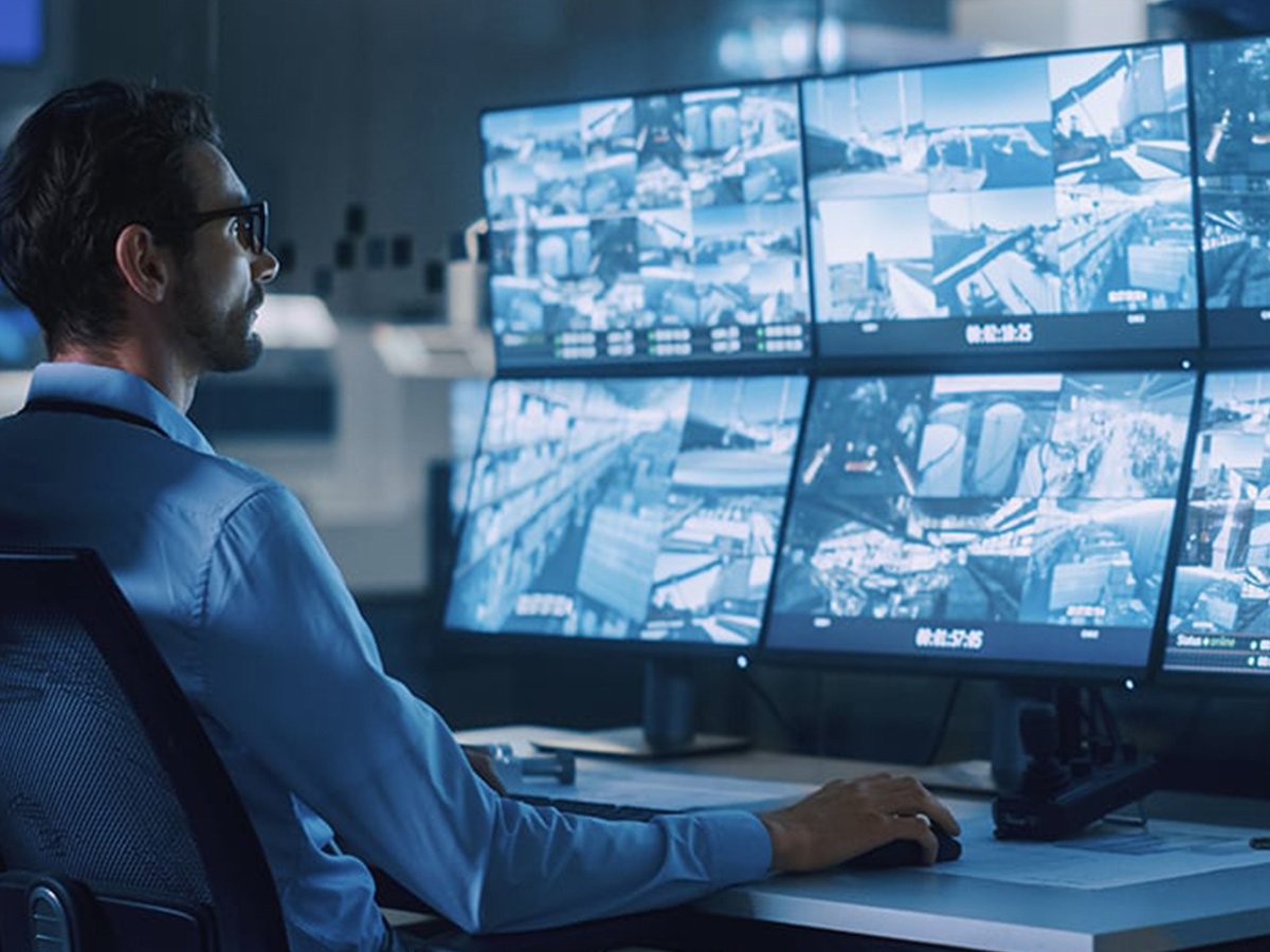 Multiple surveillance monitors showing camera feeds in a control room.