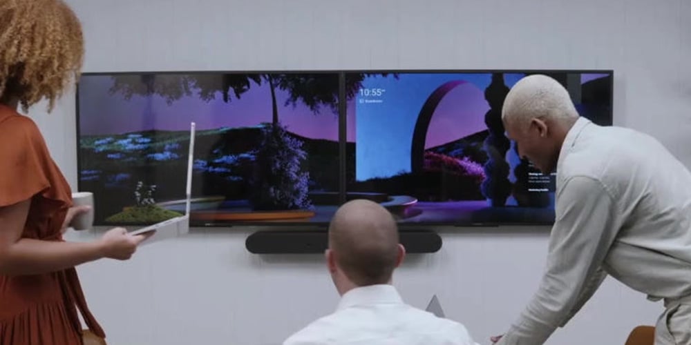 Group collaborating in front of two large wall-mounted screens.