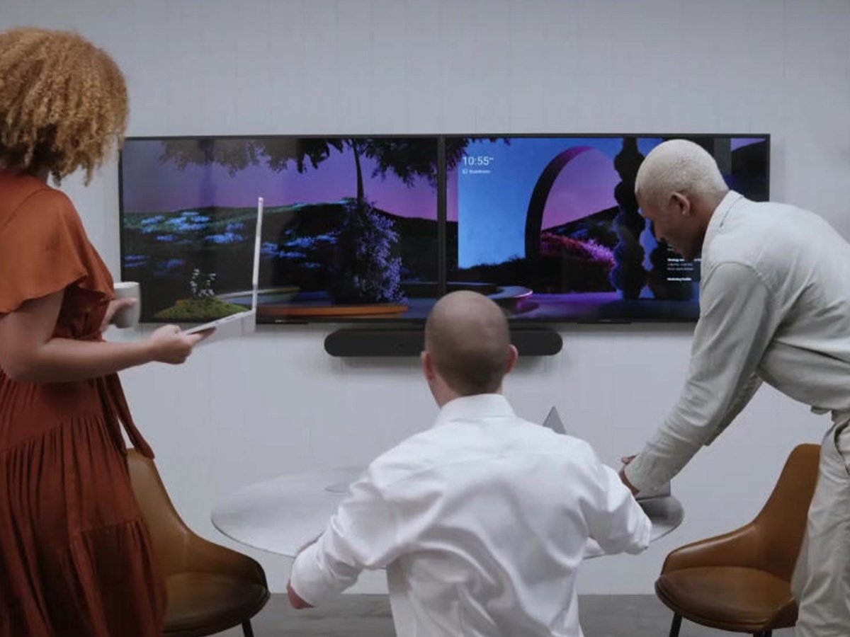 Group collaborating in front of two large wall-mounted screens.