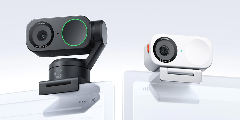 Two clip-on webcams, one black and one white, attached to screens.