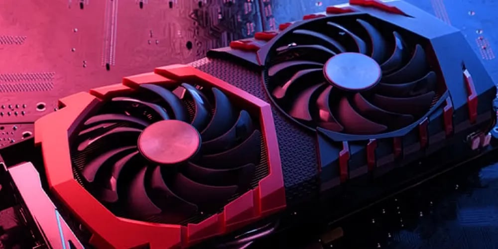 Close‑up of a graphics card with dual cooling fans mounted on a circuit board, lit in red and blue light.