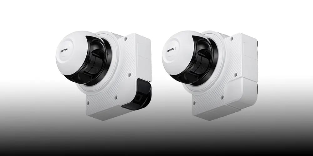 Two white wall-mounted security cameras with black lenses, shown against a plain light background.