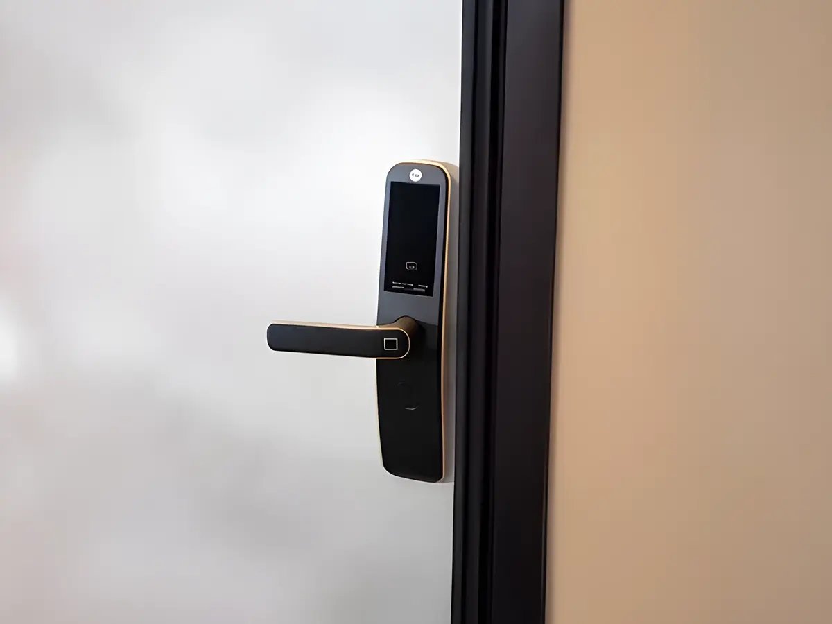 Modern smart door lock on a frosted glass door. The sleek black design features a digital touchscreen and a handle, conveying a futuristic feel.