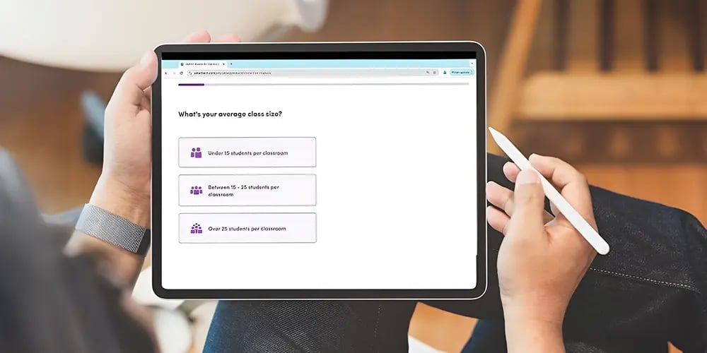 A person holding a tablet with a survey on average class size. Options include 