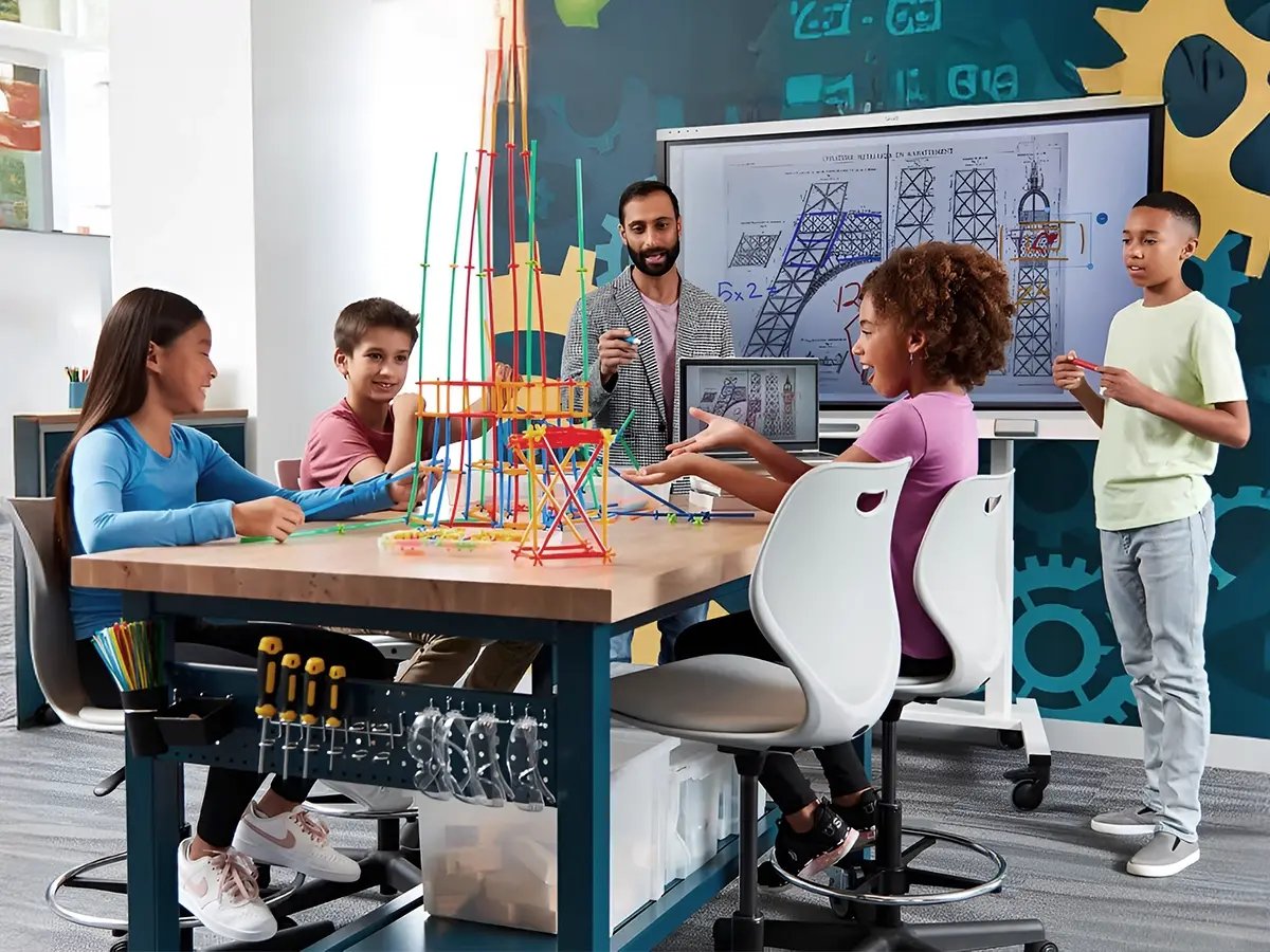 Students and a teacher engage in a STEM class. They build a colorful tower with connectors. A screen shows technical drawings. Mood: collaborative, educational.