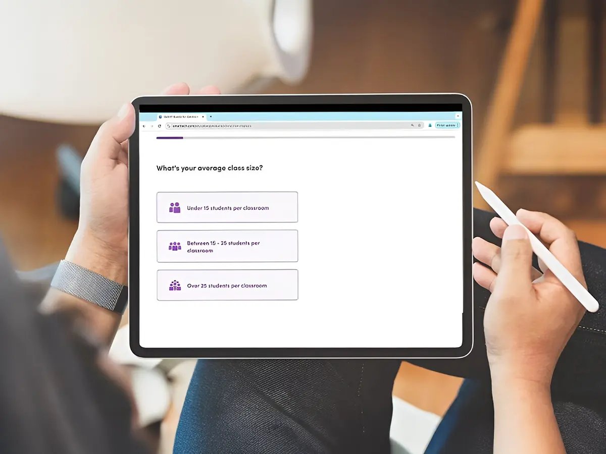 A person holding a tablet with a survey on average class size. Options include 
