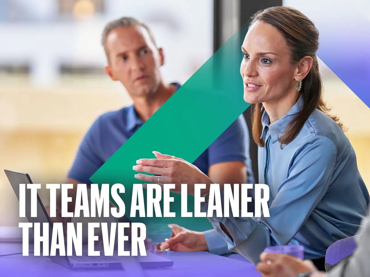 Two people in conversation at a desk with laptops, text overlay: “IT teams are leaner than ever.”
