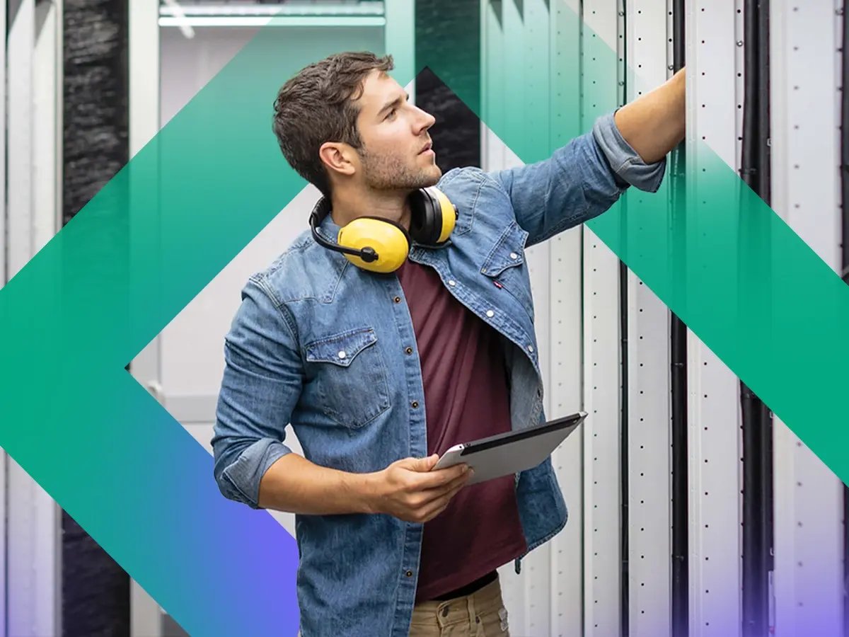 Person seated at a desk working on a computer with multiple large monitors displaying data.