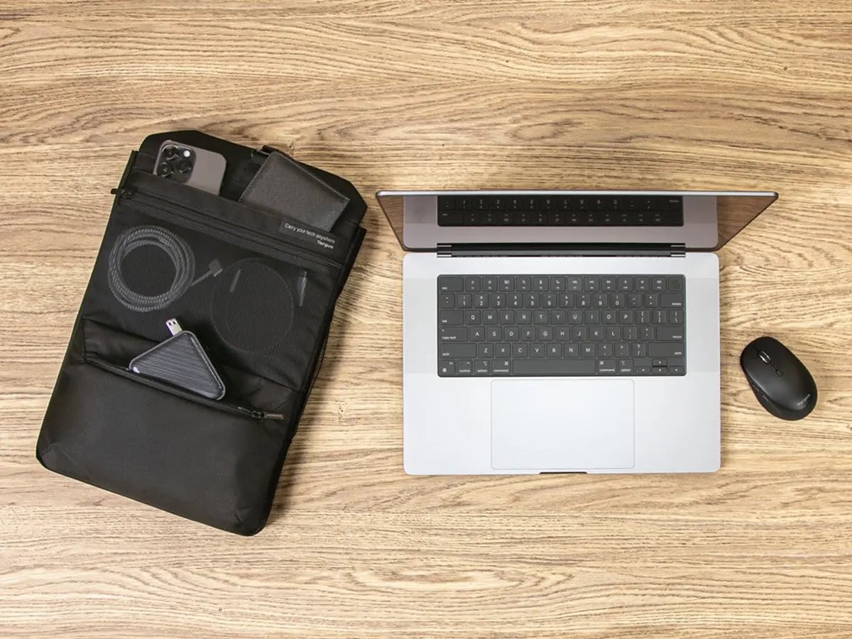 A Targus Ecosmart laptop bag beside a laptop on a wooden tabletop.