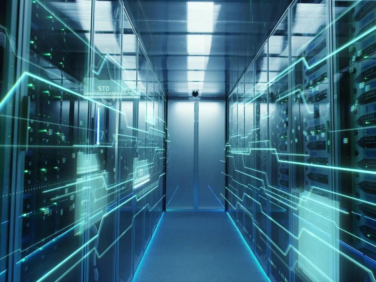 A brightly lit data center corridor with rows of server racks on both sides, overlaid with glowing digital lines and network graphics, symbolizing data flow and connectivity.