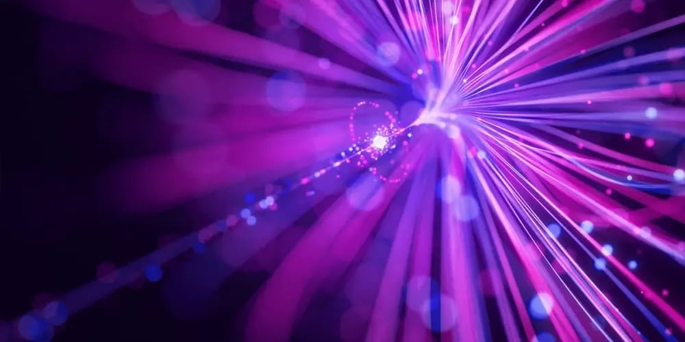 Abstract image of bright pink and purple light streaks radiating outward on a dark background, symbolizing speed and seamless connectivity.