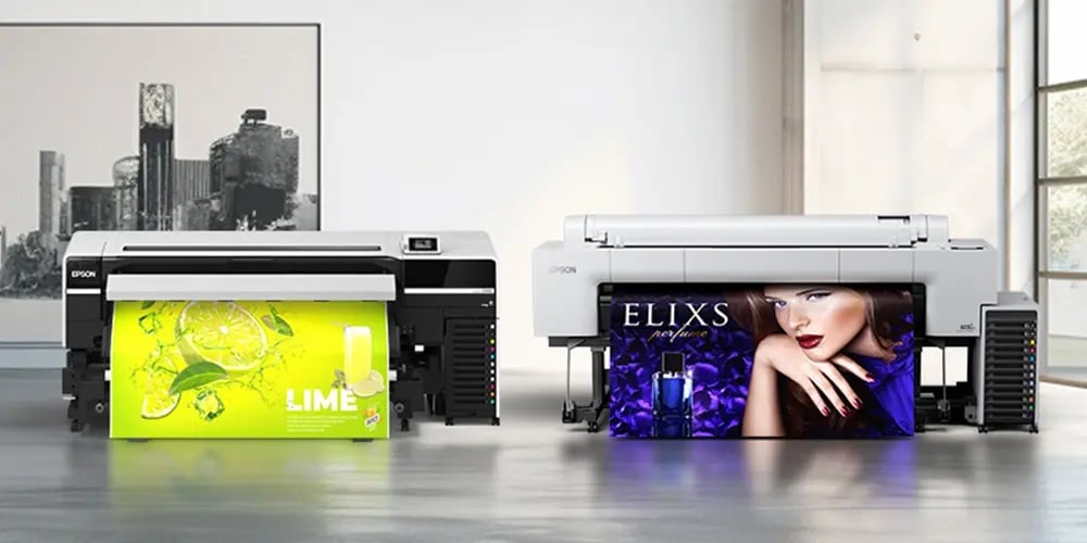 Two Epson large format printers displaying vibrant printed banners, one with a lime-themed design and the other with a perfume advertisement.