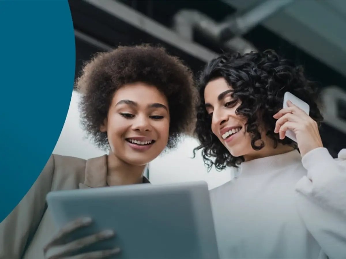 Two people are collaborating on mobile fleet management, using a tablet and a smartphone to review data or manage devices.