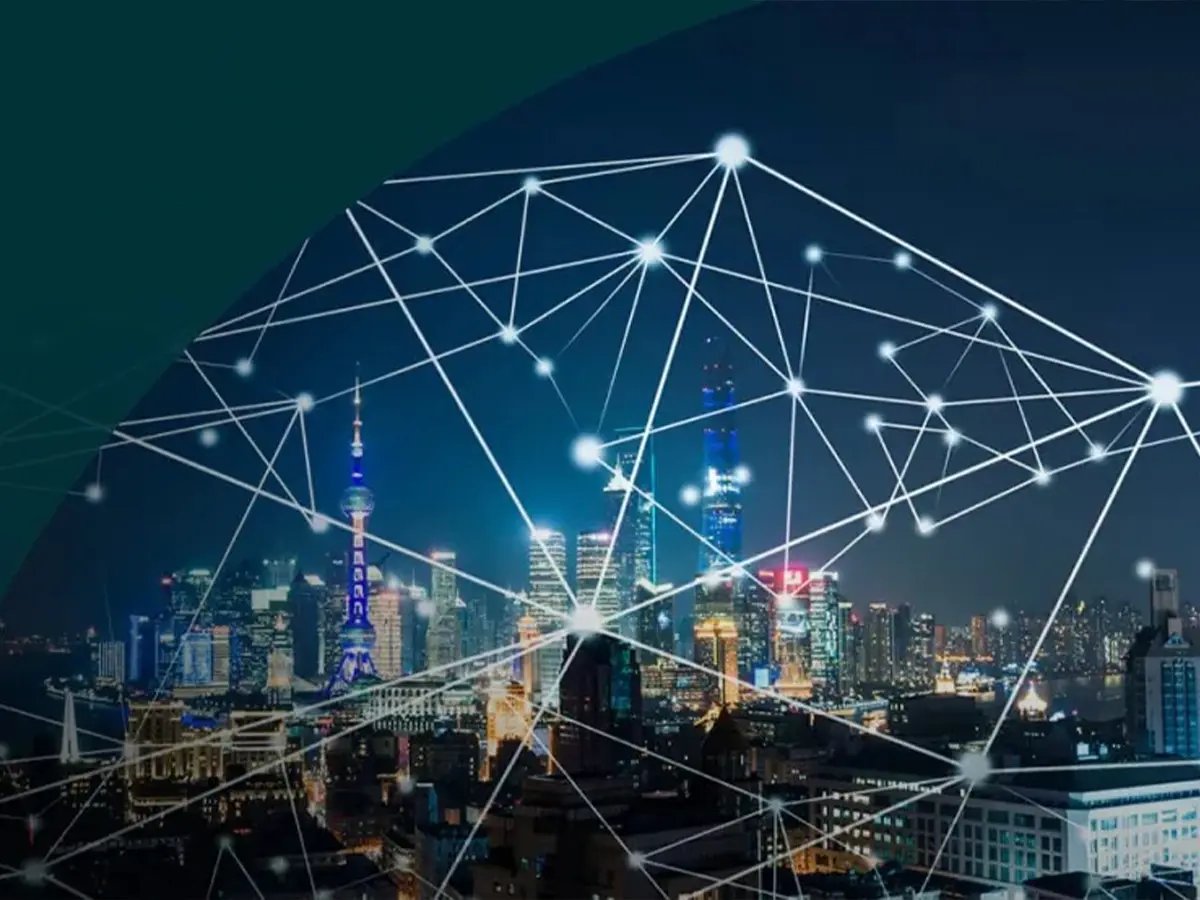City skyline at night with illuminated buildings overlaid by connected network lines and nodes.