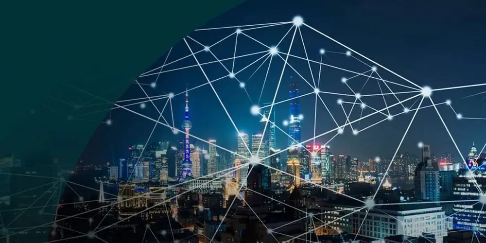 City skyline at night with illuminated buildings overlaid by connected network lines and nodes.