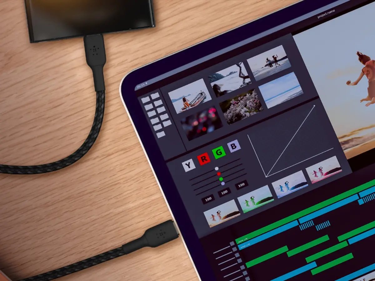 A tablet displaying a video editing interface, connected with braided cables.