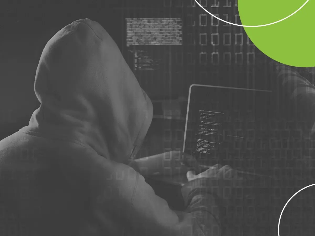 Hooded figure in a dark environment with digital code in the background.