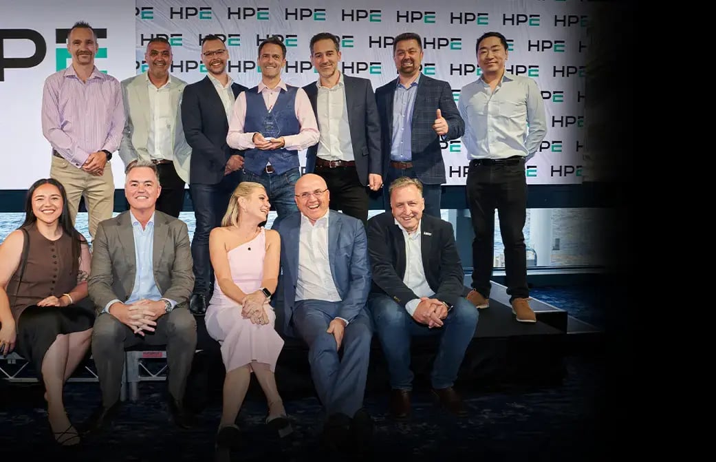 Group of professionals posing together on a stage at an HPE‑branded business event or conference.