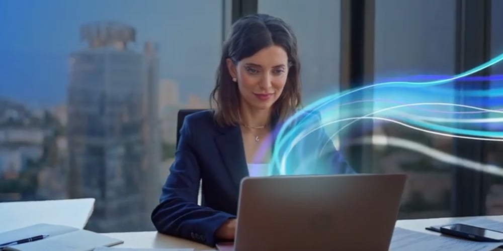 Person working on a laptop at a desk, with abstract blue data lines illustrating secure connectivity.